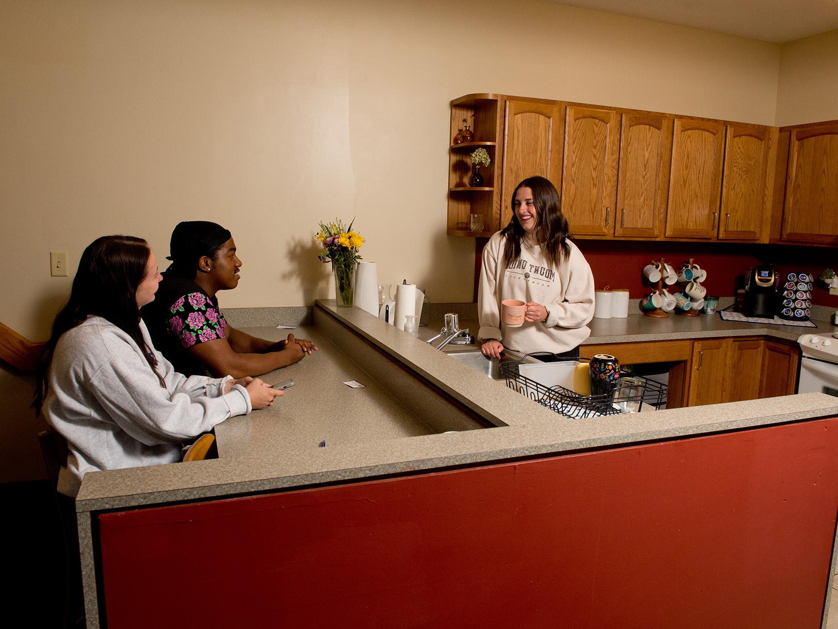 Students hanging out in the kitchen of a townhouse