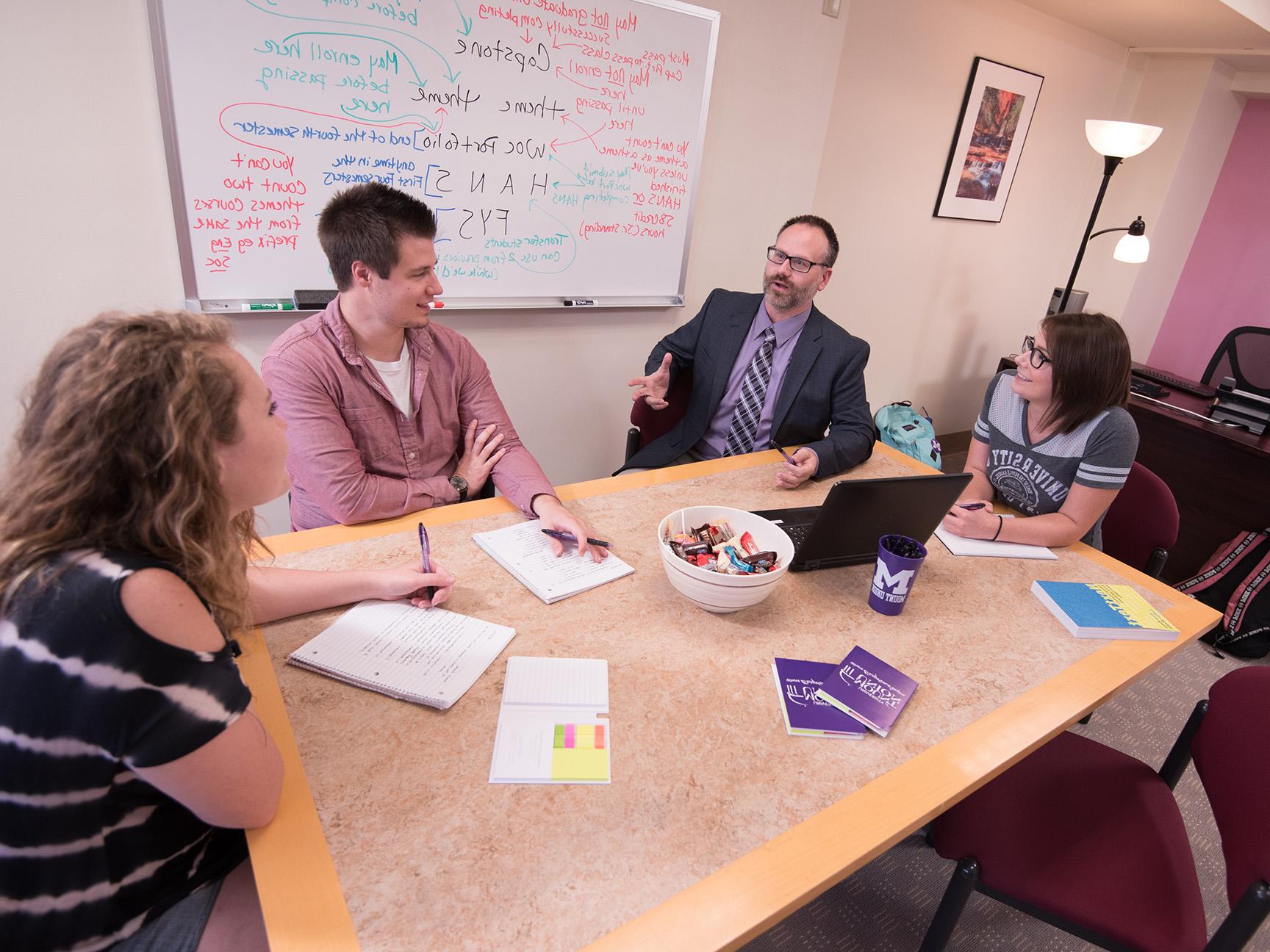 Students and a faculty member participating in an advising session